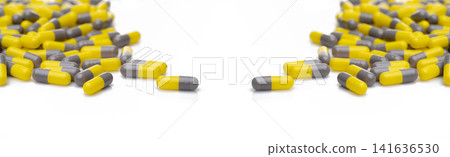 Yellow and gray probiotic capsule pill on white background. Probiotic supplement. Gut health. Dietary supplements. Probiotics for a healthy gut. Lactobacillus acidophilus and Bifidobacterium animalis. Yellow and gray probiotic capsule pill on white background. Probiotic supplement. Gut health. Dietary supplements. Probiotics for a healthy gut. Lactobacillus acidophilus and Bifidobacterium animalis. 141636530