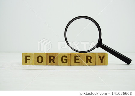 FORGERY alphabet letters with magnifying glass on wooden background FORGERY alphabet letters with magnifying glass on wooden background 141636668