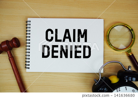 Claim Denied text written on notepad with pen, alarm clock and judge gavel on wooden background Claim Denied text written on notepad with pen, alarm clock and judge gavel on wooden background 141636680