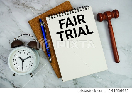 Fair Trial text written on notepad with pen, alarm clock and judge gavel on marble background Fair Trial text written on notepad with pen, alarm clock and judge gavel on marble background 141636685