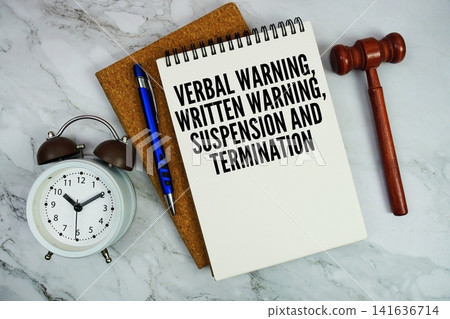 Verbal Warning, Written Warning, Suspension and Termination text written on notepad with pen, alarm clock and judge gavel on marble background Verbal Warning, Written Warning, Suspension and Termination text written on notepad with pen, alarm clock and judge gavel on marble background 141636714
