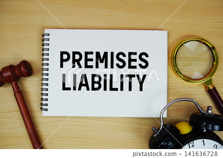 Premises Liability text written on notepad with pen, alarm clock and judge gavel on wooden background Premises Liability text written on notepad with pen, alarm clock and judge gavel on wooden background 141636728