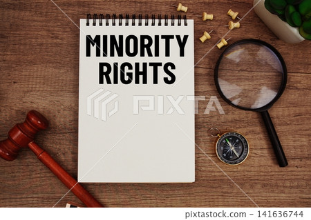 Minority Rights message written on notepad with wood gavel and magnifying glass flat lay on wooden background Minority Rights message written on notepad with wood gavel and magnifying glass flat lay on wooden background 141636744