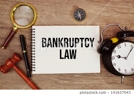 Bankruptcy Law message written on notepad with alarm clock, wood gavel and magnifying glass flat lay on wooden background Bankruptcy Law message written on notepad with alarm clock, wood gavel and magnifying glass flat lay on wooden background 141637043
