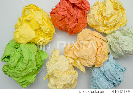multicolored crumpled paper balls round lumps scattered on a white surface multicolored crumpled paper balls round lumps scattered on a white surface 141637129