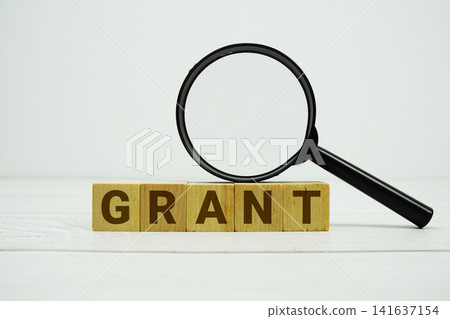 GRANT alphabet letters with magnifying glass on wooden background GRANT alphabet letters with magnifying glass on wooden background 141637154