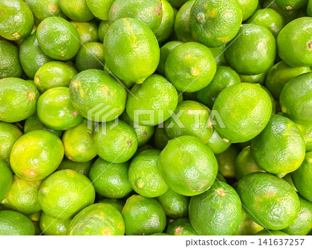 A full frame of fresh green limes piled together at a market. A full frame of fresh green limes piled together at a market. 141637257