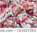 Fresh ginger roots packed in red mesh bags at a market 141637263