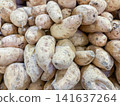 Close-up of fresh white sweet potatoes piled up in a market display. 141637264