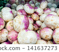 Fresh purple top turnips piled high in a grocery store produce section 141637273