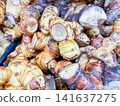 Fresh galangal root rhizomes piled together in a market display 141637275