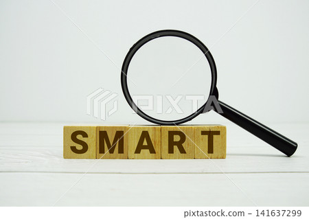 SMART alphabet letters with magnifying glass on wooden background SMART alphabet letters with magnifying glass on wooden background 141637299