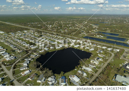 Wind damage of private houses after hurricane swept through Florida mobile home residential area. Consequences of natural disaster Wind damage of private houses after hurricane swept through Florida mobile home residential area. Consequences of natural disaster 141637480