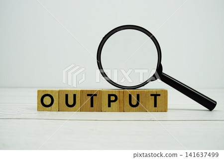 OUTPUT alphabet letters with magnifying glass on wooden background 141637499