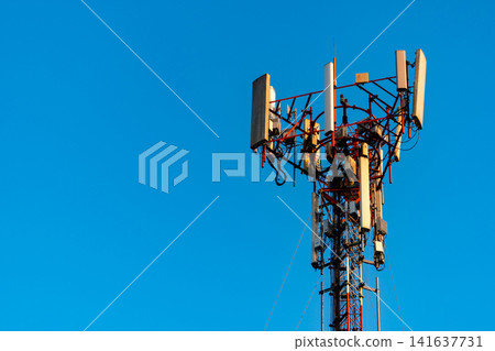 Cellular communication tower with wireless antennas under blue sky, modern telecommunications infrastructure for mobile networks, broadband internet, smart city technology and digital communication. 141637731