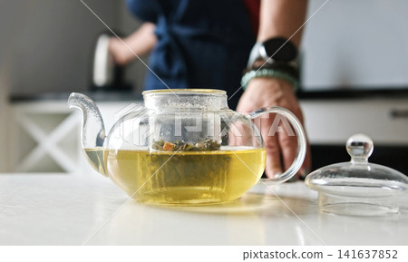 Girl Making A Green Tea In Teapot In The Kitchen For Breakfast Girl Making A Green Tea In Teapot In The Kitchen For Breakfast 141637852