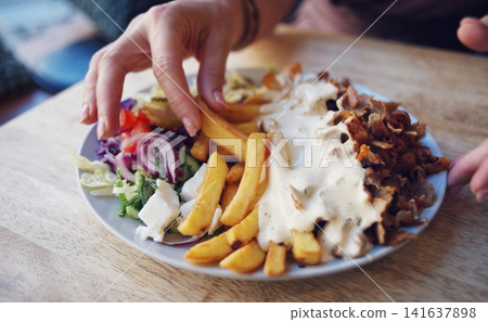 Grilled Meat, Chopped, With Vegetables And Fries On A Table Grilled Meat, Chopped, With Vegetables And Fries On A Table 141637898