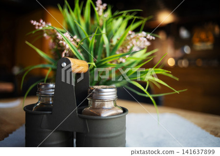 Salt And Pepper Shakers On A Table At A Cozy Restaurant Salt And Pepper Shakers On A Table At A Cozy Restaurant 141637899