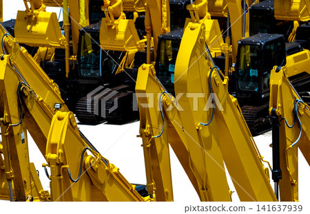 Rows of yellow hydraulic excavators with powerful boom arms parked at heavy equipment yard. Construction machinery, civil engineering, industrial technology and infrastructure development. 141637939