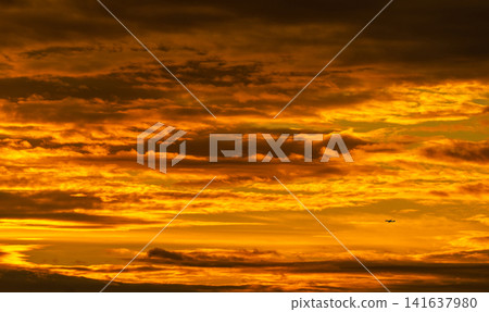 Silhouette small airplane flying on beautiful sunset sky. Golden vast sunset sky. Freedom and calm background. Beauty in nature. Powerful and spiritual scene. Dramatic and majestic golden sky. Silhouette small airplane flying on beautiful sunset sky. Golden vast sunset sky. Freedom and calm background. Beauty in nature. Powerful and spiritual scene. Dramatic and majestic golden sky. 141637980