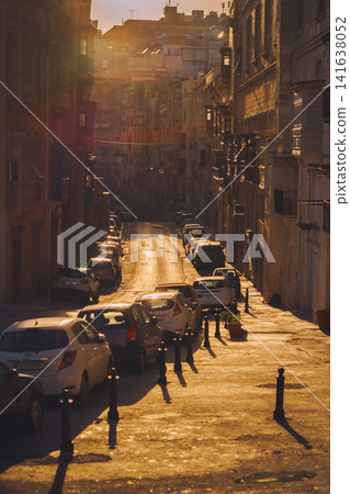 VALLETTA, MALTA - NOVEMBER 12, 2018 - Hilly ancient streets view with colourful balconies, people and cars in the medieval city VALLETTA, MALTA - NOVEMBER 12, 2018 - Hilly ancient streets view with colourful balconies, people and cars in the medieval city 141638052