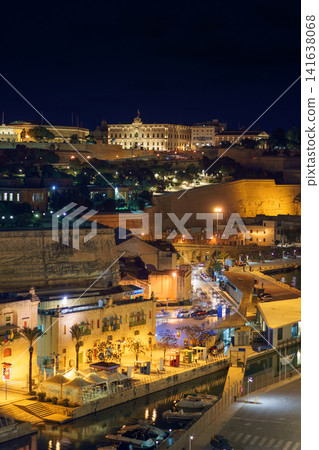 VALLETTA, MALTA - NOVEMBER 12, 2018 - Panoramic night view of a coast line and the downtown of the city with different landmarks VALLETTA, MALTA - NOVEMBER 12, 2018 - Panoramic night view of a coast line and the downtown of the city with different landmarks 141638068