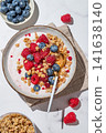 Natural greek yogurt with granola, blueberry and raspberry in a bowl on a marble background 141638140