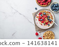 Natural greek yogurt with granola, blueberry and raspberry in a bowl on a marble background 141638141