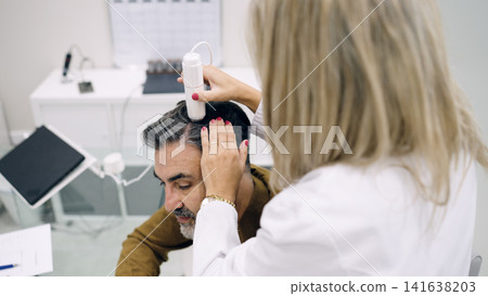 Trichologist analyzing man's hair scalp for treatment Trichologist analyzing man's hair scalp for treatment 141638203