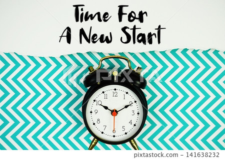Time For A New Start text written on paper with alarm clock on green chevron background Time For A New Start text written on paper with alarm clock on green chevron background 141638232