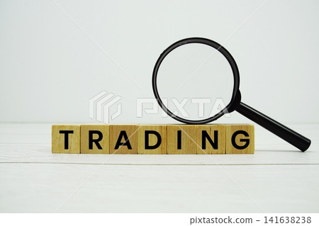 TRADING alphabet letters with magnifying glass on wooden background TRADING alphabet letters with magnifying glass on wooden background 141638238