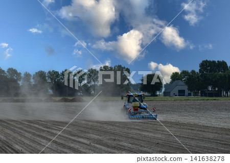 Blue Tractor Cultivating Dry Dusty Field Blue Tractor Cultivating Dry Dusty Field 141638278