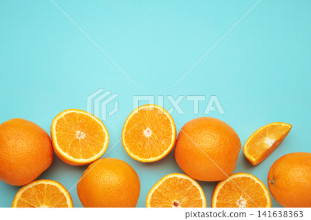 Fresh orange fruits and slices on blue background. Fresh orange fruits and slices on blue background. 141638363
