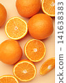 Whole and half of orange fruit on beige background. Vertical photo 141638383