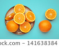 Fresh orange fruit on plate on blue background. 141638384