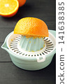Squeezer and orange fruits on black wooden background. Vertical photo 141638385