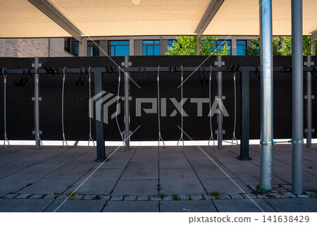 Modern covered bike parking racks in Fuerstenfeldbruck, Bavaria, Germany, empty bicycle parking area in urban street on sunny day Modern covered bike parking racks in Fuerstenfeldbruck, Bavaria, Germany, empty bicycle parking area in urban street on sunny day 141638429