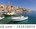 Boats Moored in Symi Harbor with Colorful Hillside Town on Symi Island Greece 141638459