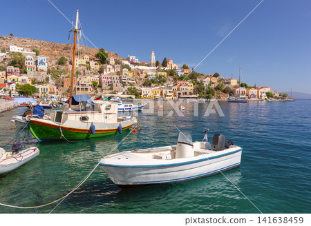 Boats Moored in Symi Harbor with Colorful Hillside Town on Symi Island Greece Boats Moored in Symi Harbor with Colorful Hillside Town on Symi Island Greece 141638459