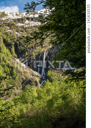 Polikarpiya waterfall cascading down rocky cliff with lush green vegetation - Sochi, Russia Polikarpiya waterfall cascading down rocky cliff with lush green vegetation - Sochi, Russia 141638535