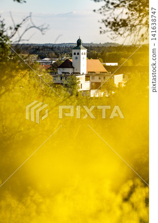 Vibrant Yellow Rapeseed Field With Gilching Village Church In Background - Bavarian Countryside Spring Landscape, Blooming Canola, Rural Bavaria Germany, Soft Bokeh Vibrant Yellow Rapeseed Field With Gilching Village Church In Background - Bavarian Countryside Spring Landscape, Blooming Canola, Rural Bavaria Germany, Soft Bokeh 141638747