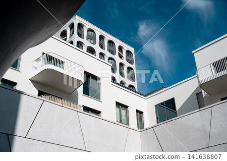Modern Munich Residential Complex - Upward Perspective - Contemporary White Architecture Against Blue Sky Modern Munich Residential Complex - Upward Perspective - Contemporary White Architecture Against Blue Sky 141638807