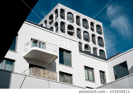 Modern Munich Residential Complex - Upward Perspective - Contemporary White Architecture Against Blue Sky Modern Munich Residential Complex - Upward Perspective - Contemporary White Architecture Against Blue Sky 141638811
