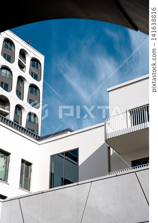 Modern Munich Residential Complex - Upward Perspective - Contemporary White Architecture Against Blue Sky Modern Munich Residential Complex - Upward Perspective - Contemporary White Architecture Against Blue Sky 141638816