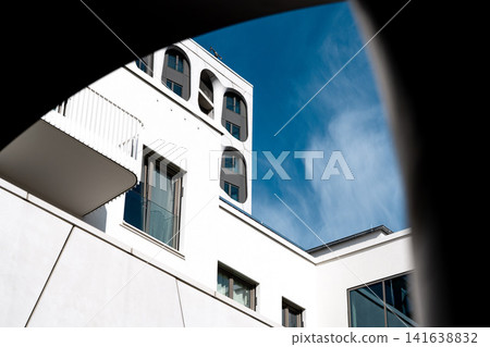 Modern Munich Residential Complex - Upward Perspective - Contemporary White Architecture Against Blue Sky Modern Munich Residential Complex - Upward Perspective - Contemporary White Architecture Against Blue Sky 141638832