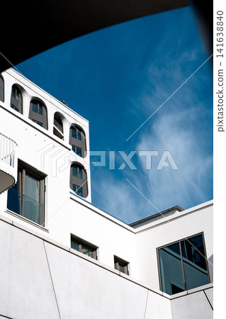 Modern Munich Residential Complex - Upward Perspective - Contemporary White Architecture Against Blue Sky Modern Munich Residential Complex - Upward Perspective - Contemporary White Architecture Against Blue Sky 141638840