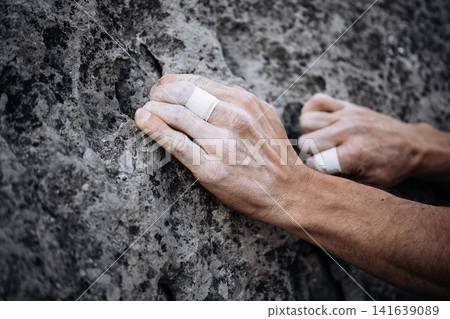 Climber Using Side Pocket Grip With Taped Fingers On Rock Surface: Close Up Of Precision Hand Placement Outdoors 141639089