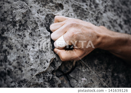 Climber Using Side Pocket Grip With Taped Fingers On Rock Surface: Close Up Of Precision Hand Placement Outdoors Climber Using Side Pocket Grip With Taped Fingers On Rock Surface: Close Up Of Precision Hand Placement Outdoors 141639126