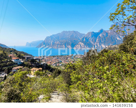 Panoramic View Over Riva Del Garda From Belvedere Climbing Garden: Scenic Landscape In Province Of Trento At Lake Garda Italy Panoramic View Over Riva Del Garda From Belvedere Climbing Garden: Scenic Landscape In Province Of Trento At Lake Garda Italy 141639158