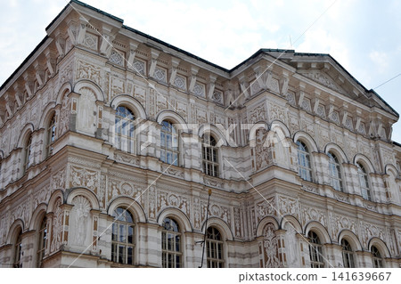 Detailed ornate neoclassical building facade in Prague showing decorative reliefs and arched windows for architectural background and texture design Detailed ornate neoclassical building facade in Prague showing decorative reliefs and arched windows for architectural background and texture design 141639667